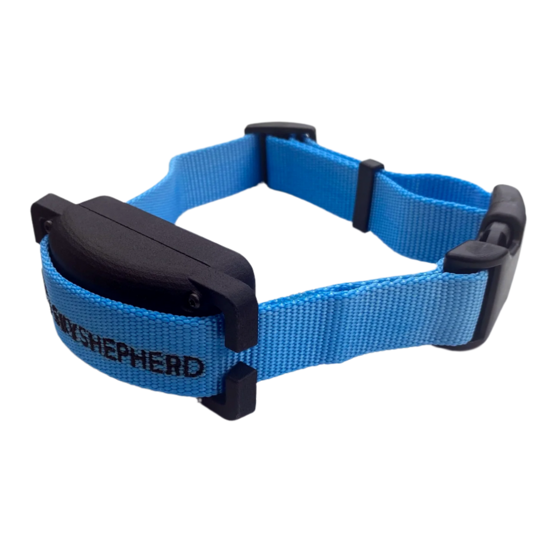 The black plastic SkyShepherd collar unit at a three-quarter aspect from the front. The SkyShepherd blue collar strap is attached through the integrated brackets of the collar unit. The black SkyShepherd logo is embroidered on the collar strap, and is partially visible to the viewer. The collar strat is clasped with a black plastic pinch buckle that is typical of nylon collar straps.