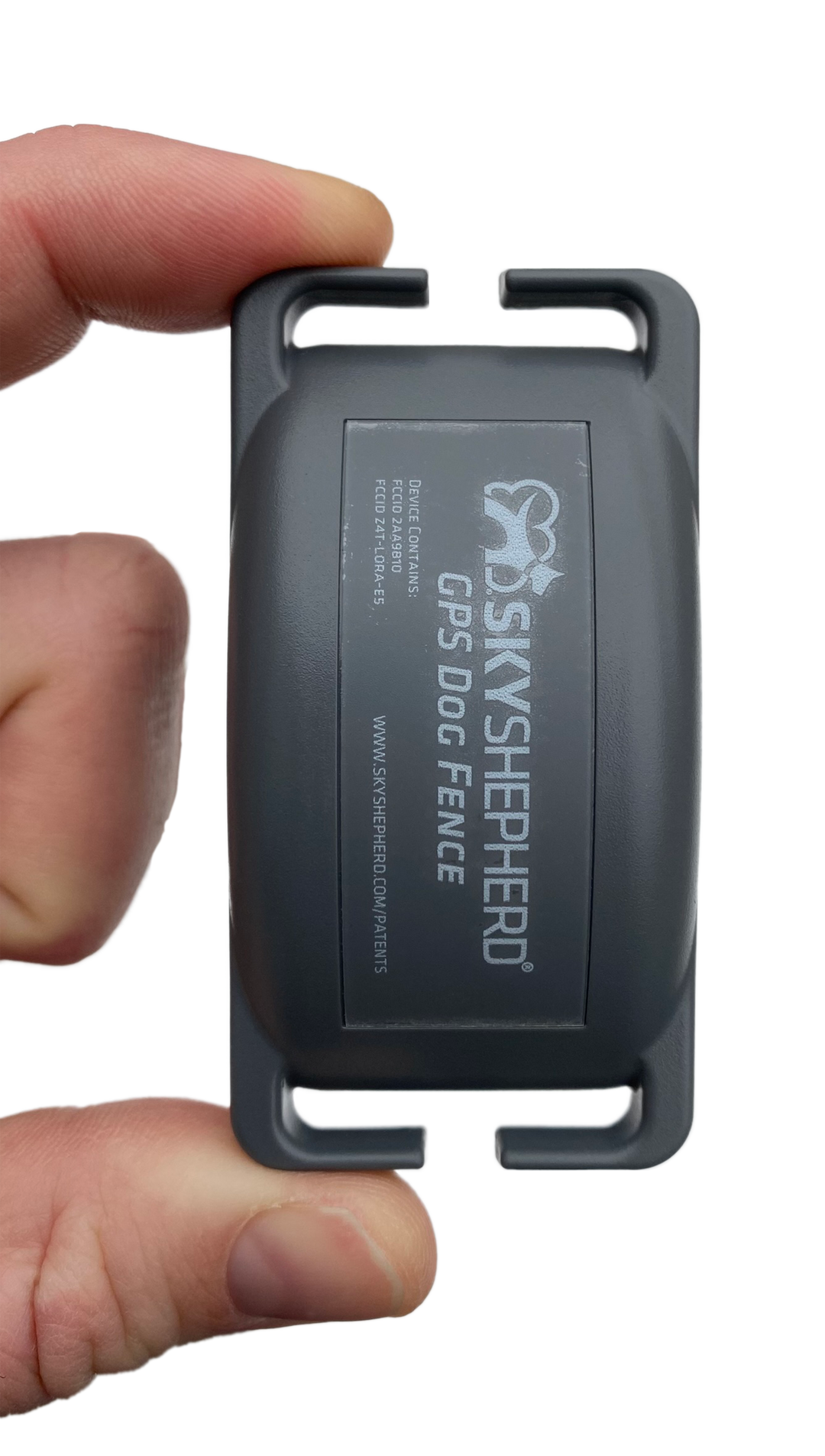 A hand easily holds the SkyShepherd GPS collar unit between index finger and thumb.
